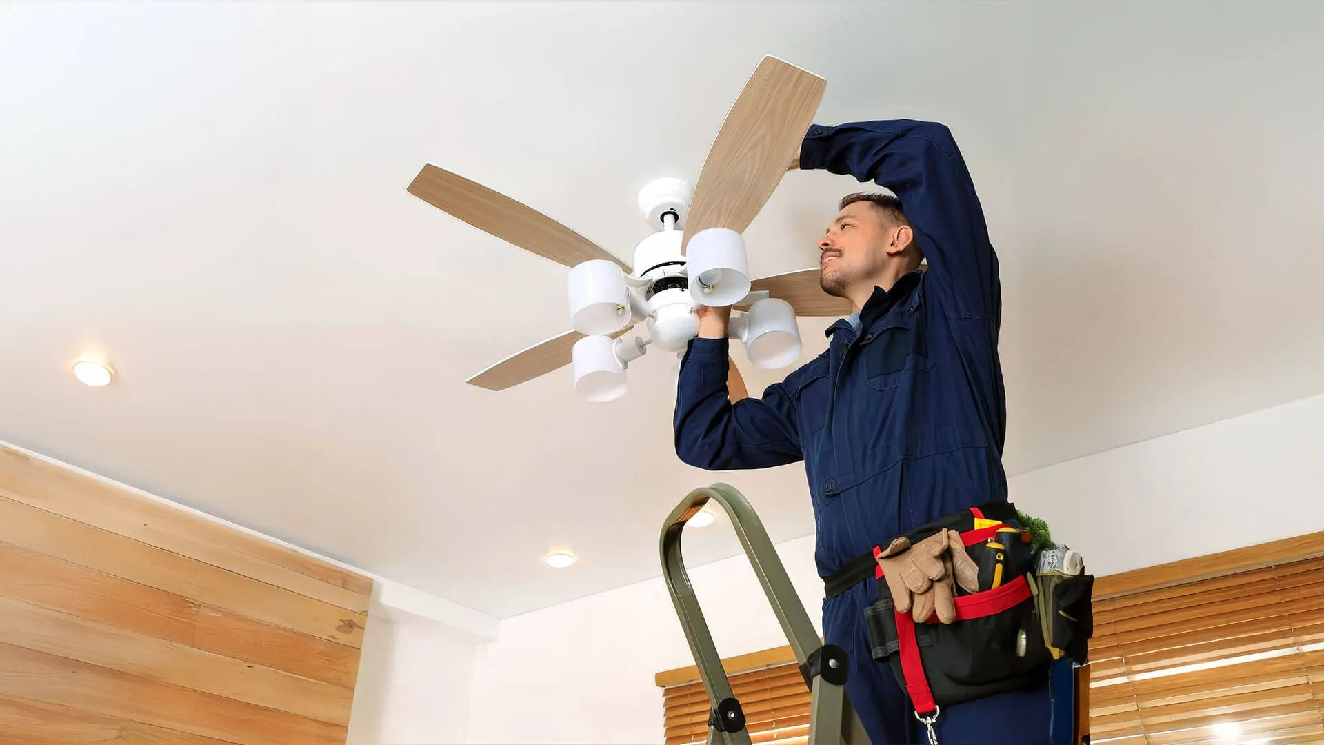Licensed electrician installing a ceiling fan in a Gold Coast home