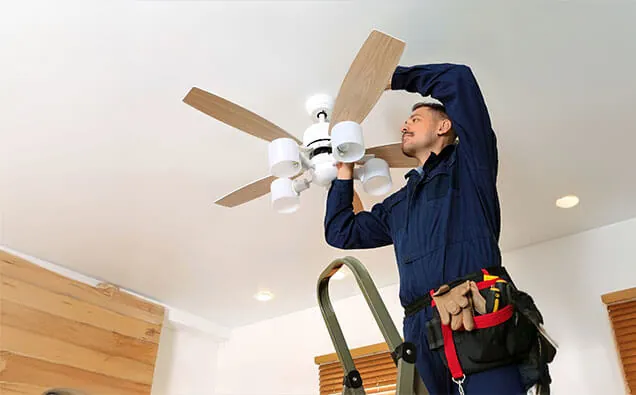 Licensed electrician mounting a ceiling fan bracket on the Gold Coast