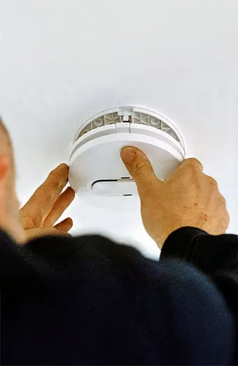 Electrician testing interconnected smoke alarm on Gold Coast